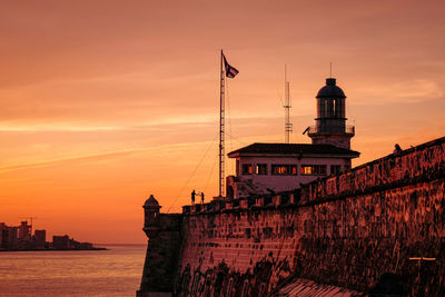 View of building against cloudy sky during sunset