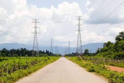 Road amidst field against sky