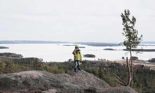 Young boy posing for a photo on a rock with a beautful view behind