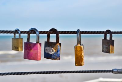 Close-up of padlocks on railing against bridge