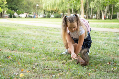 Side view of young woman sitting on field