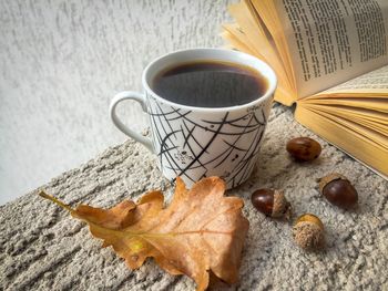 Close-up of coffee with book and leaf