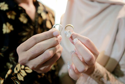 Midsection of couple holding hands