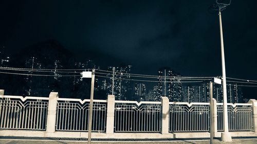 Illuminated railing against sky at night