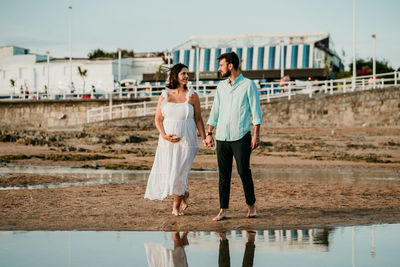 Rear view of friends standing by water