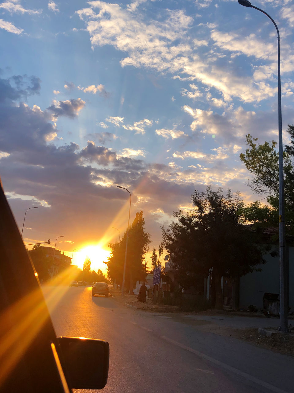 CARS ON ROAD AGAINST SKY DURING SUNSET