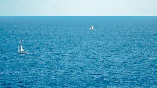 Sailboat sailing in sea against sky