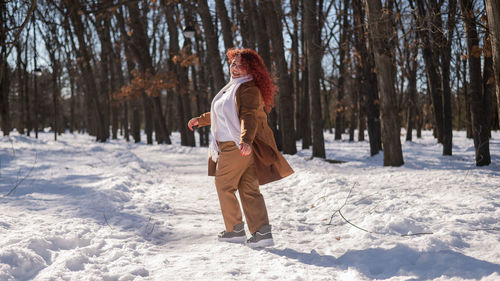Full length of woman standing on snow covered landscape