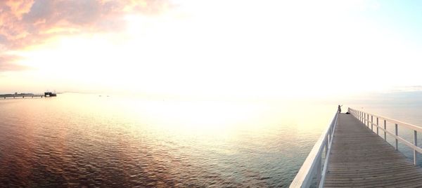 Pier on sea during sunset