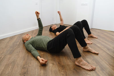 Rehabilitation exercise. physical therapy concept. two people laying on the back on the floor with