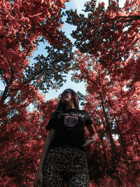 Low angle view of woman standing against trees