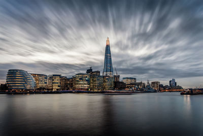 Shard london bridge by thames river in city at dusk