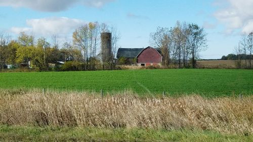 Barn on field against sky