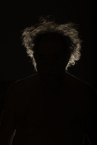 Portrait of man against black background