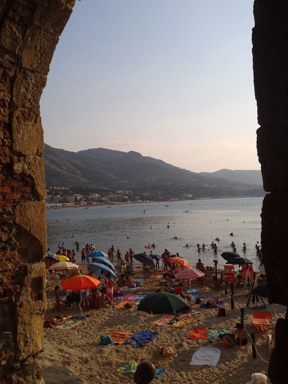 PEOPLE RELAXING ON BEACH AGAINST CLEAR SKY