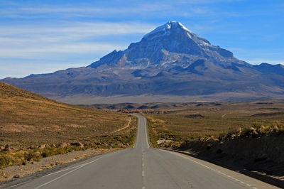 Road amidst snowcapped mountains against sky