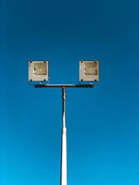 Low angle view of street light against clear blue sky