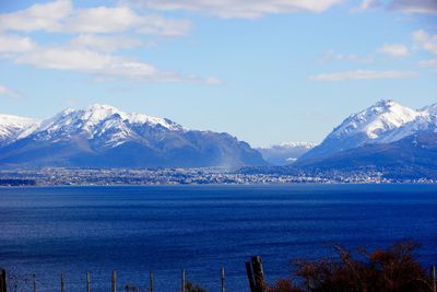 Scenic view of sea and mountains against sky during winter