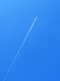 Low angle view of vapor trail in blue sky