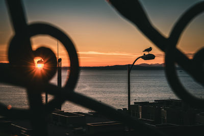 Close-up of silhouette boat against sea during sunset