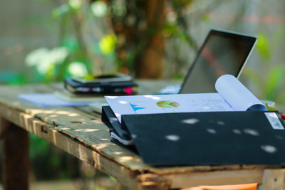 Close-up of files and laptop on table