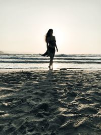 Full length of woman on beach against clear sky