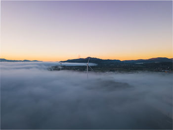 Panoramic view of wind farms in heavy fog in the morning during the rising sun