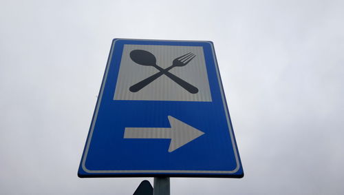 Low angle view of road sign against sky