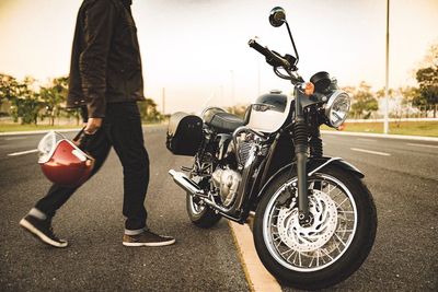 Man riding motorcycle on road against sky