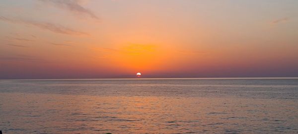 Scenic view of sea against romantic sky at sunset