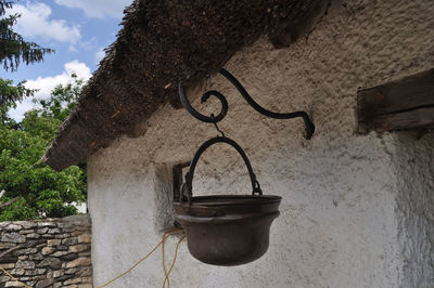 Low angle view of electric hanging on wall against building