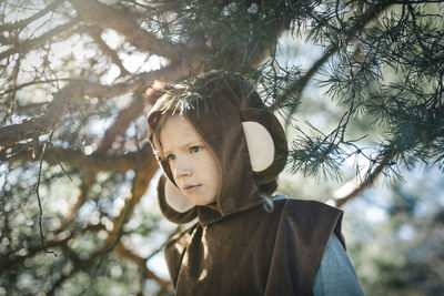 Curious girl in monkey suit standing at yard