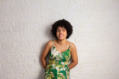 Young woman standing against wall