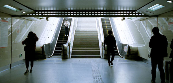 Rear view of people walking in subway