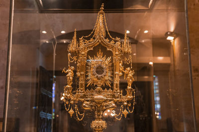 Close-up of religious offering in transparent glass cabinet at la seu cathedral