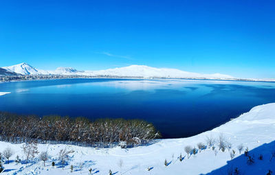 Scenic view of snowcapped mountains against blue sky