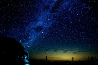 Illuminated street against sky at night