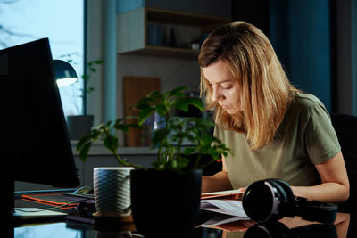 Tired woman works late at home workplace in the night