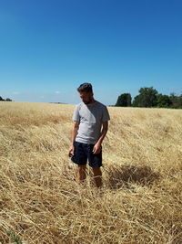 Full length of man standing on field against clear sky