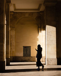 Full length of silhouette woman walking in building