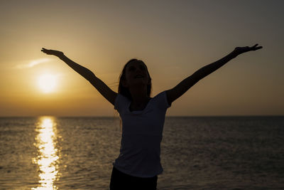 Full length of man at beach against sky during sunset