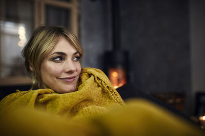 Portrait of smiling woman relaxing on couch at home in the evening