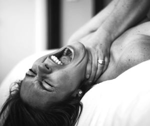 Cropped hand strangling woman neck at home