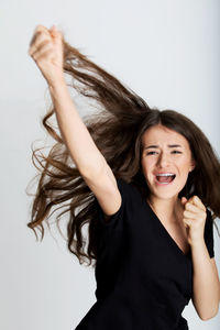 Portrait of smiling young woman against white background