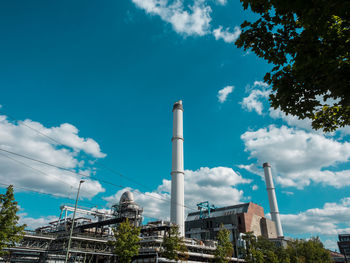 Low angle view of factory against blue sky