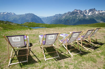 Scenic view of grassy field. scenic view of seats against mountain range 