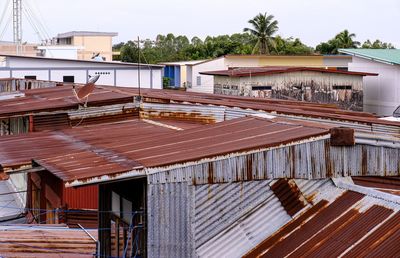 View of wooden house and building against sky