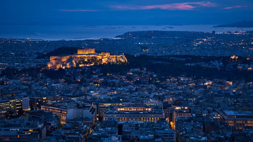 Illuminated cityscape against sky during sunset