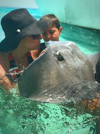 Mother and son with stingray in swimming pool