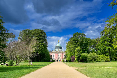 Trees in park against cloudy sky